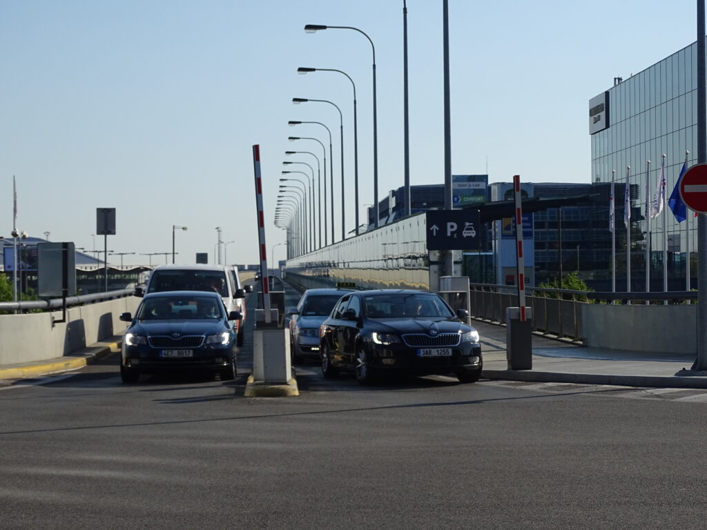 Osobní vozidla na příjezdové rampě k parkovišti P2 u Terminálu 2 Letiště Václava Havla Praha